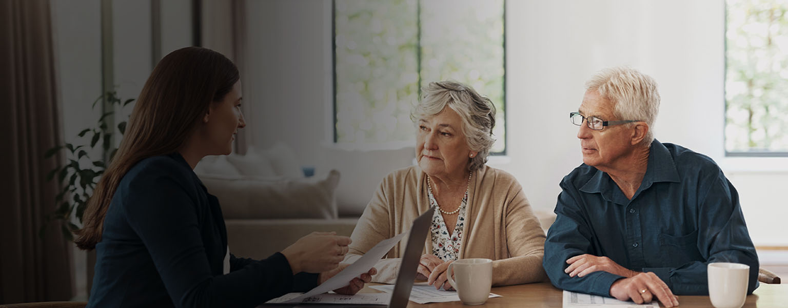 Senior couple talking with case worker.