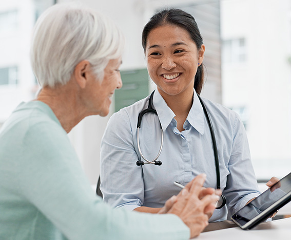 Asian caregiver consults with a senior woman.