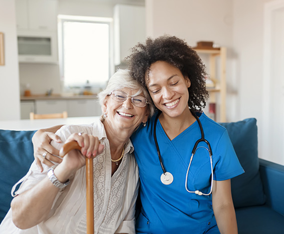 Caregiver hugging senior woman.