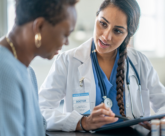 Doctora consultando con una mujer adulta mayor afroamericana.